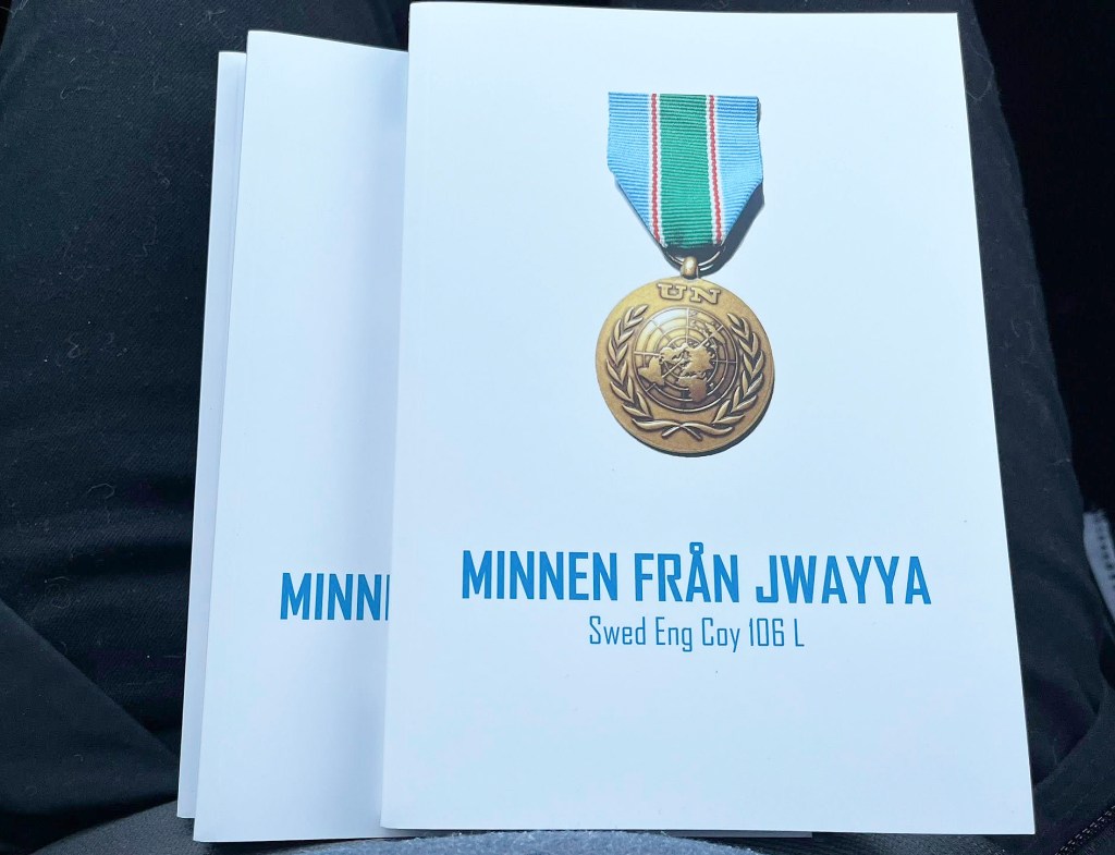 Tre böcker i en hög. På omslaget visas en FN-medalj.